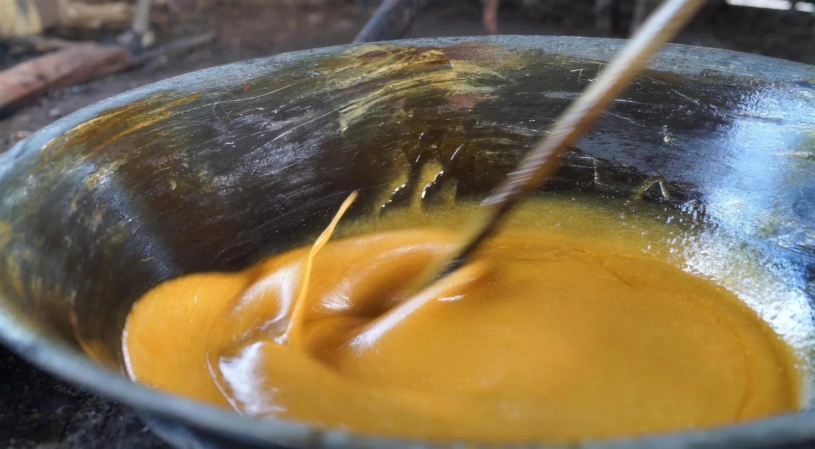Golden Gula Apong syrup swirling in a wide wok as it is stirred